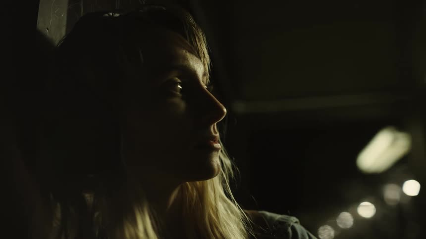 A portrait of a woman standing in a room with lights at night