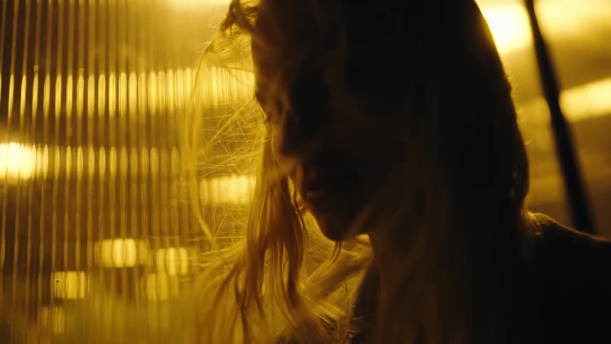 A woman is leaning by the window on a windy night