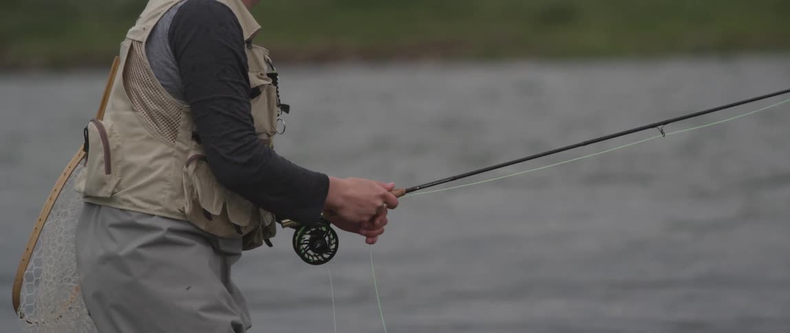 A man is fly fishing in a lake