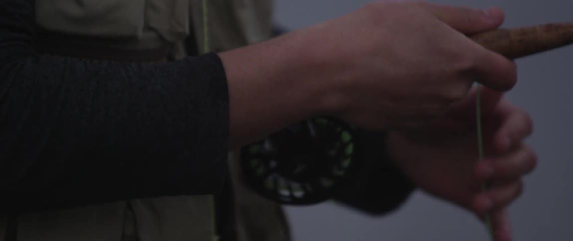A person strings a fishing line