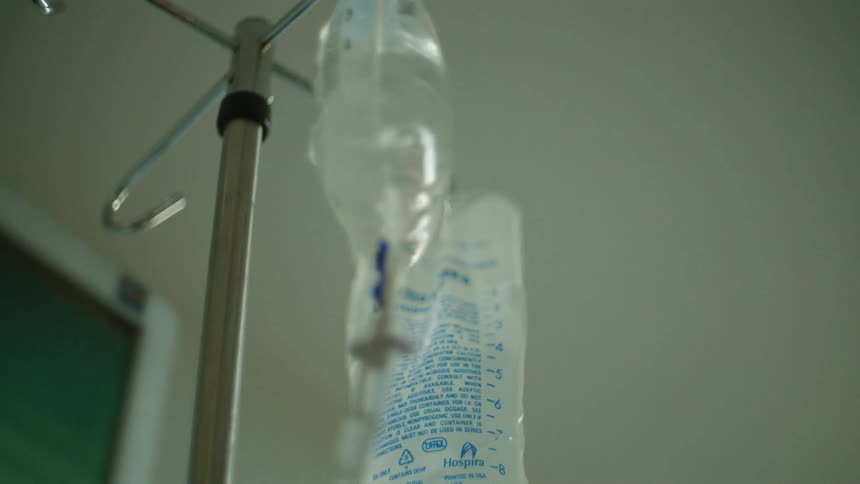 Bags of fluid hang from an iv pole setup