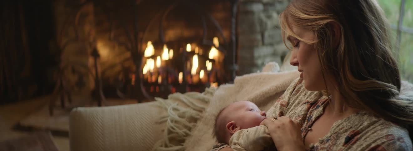 A mother cradles her son on the couch