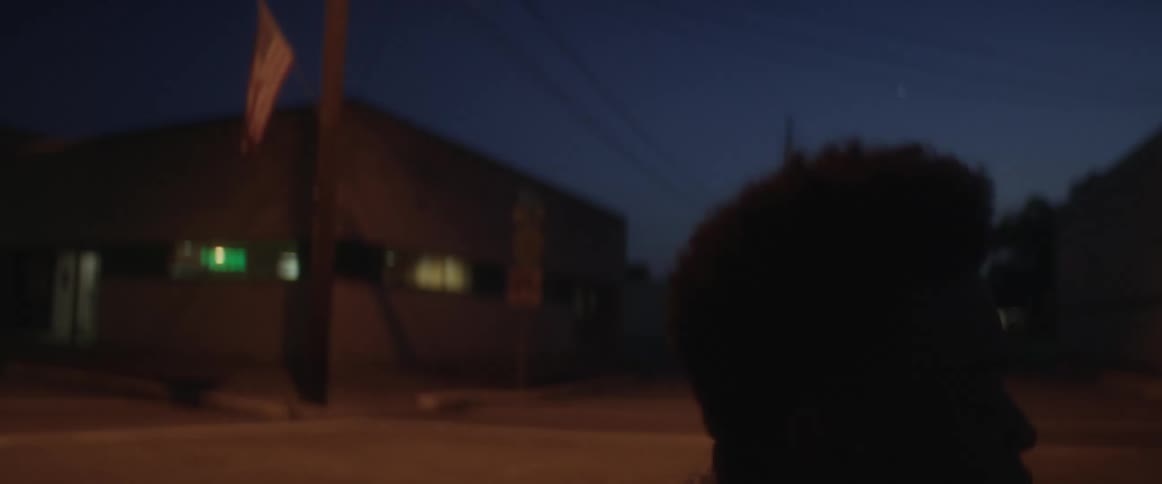 A man looks up and screens while kneeling in the street