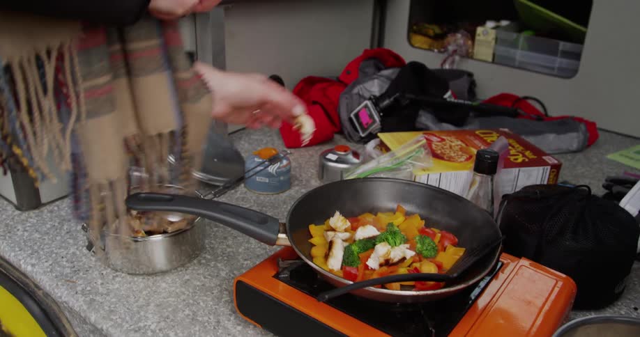 A person cooks on a hot plate