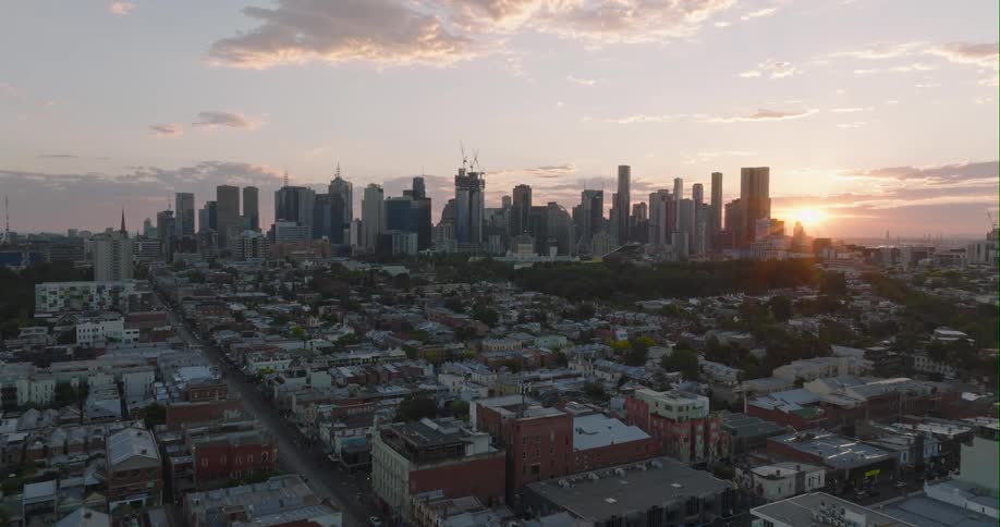The sun shines and glows behind a city skyline