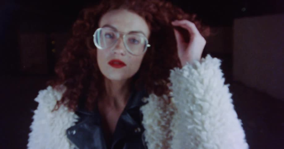 A woman pulls at her curly hair