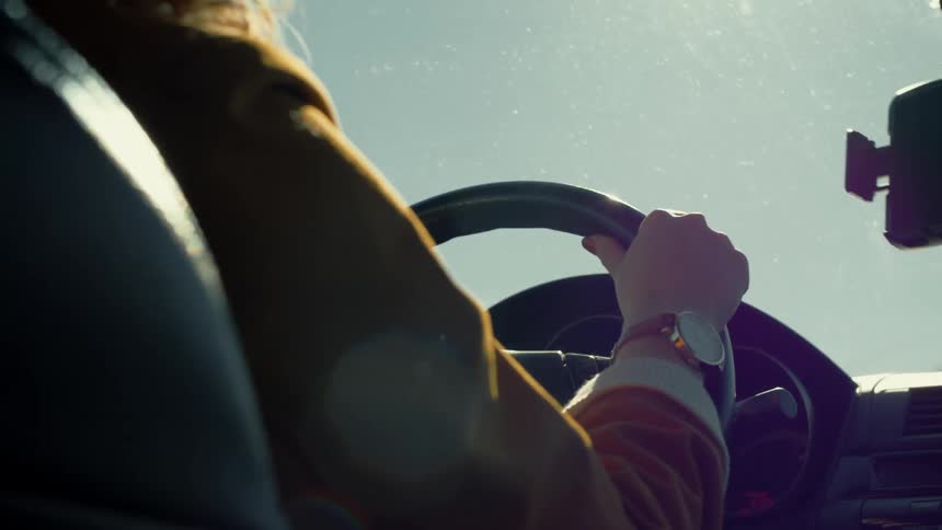 A woman driving a car on a sunny day