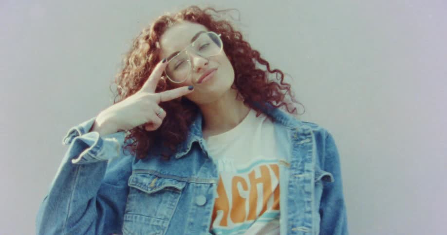 Woman with curly hair smiles and gestures
