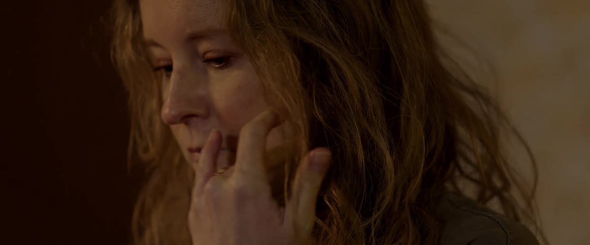 A woman is indoors and is crying