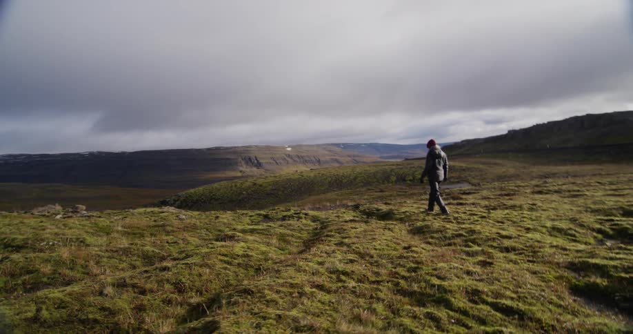 A person walks towards the edge of a plateau