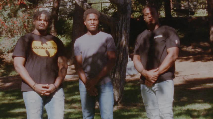 Group of friends standing on the backyard looking at the camera caught on vintage film