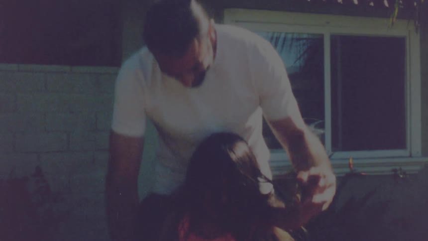 A father is playing with his daughter outside