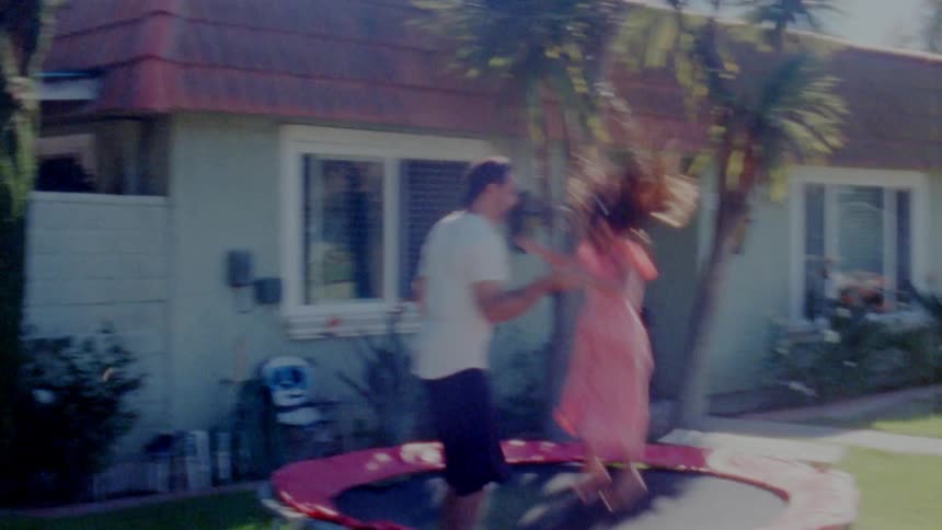 Father is jumping on a trampoling with his daughter