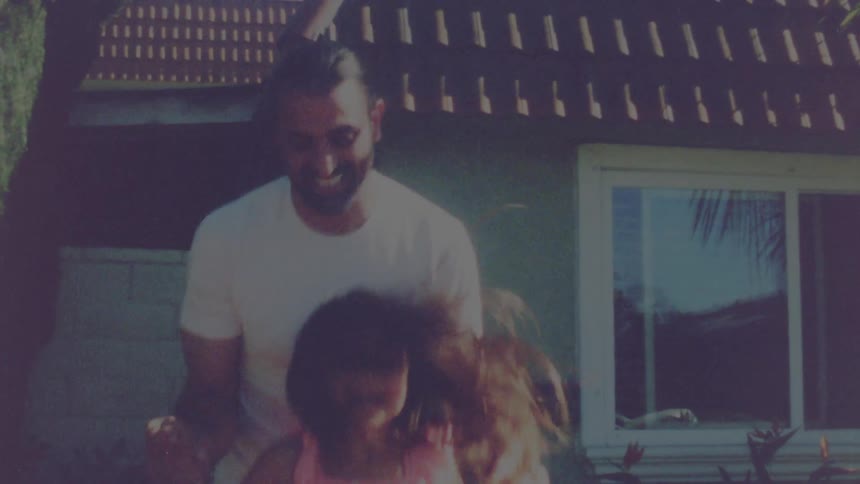 A man and girl jump around together in the yard