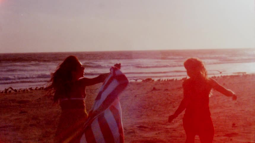 Two women running out on the beach