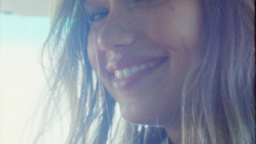 A close up of a woman putting on a hat