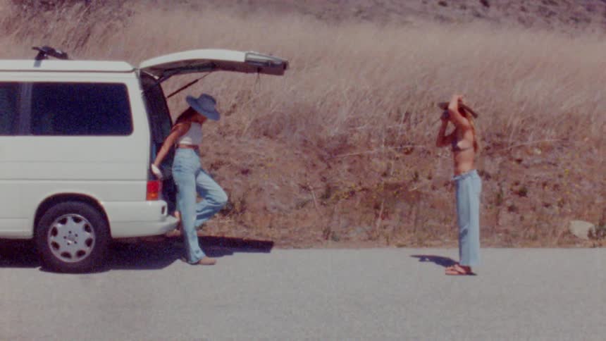 Females taking photos near a car