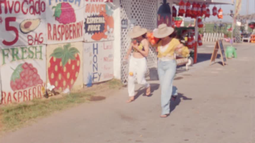 Two young friends running from a roadside store with fruit on their hands caught on vintage film