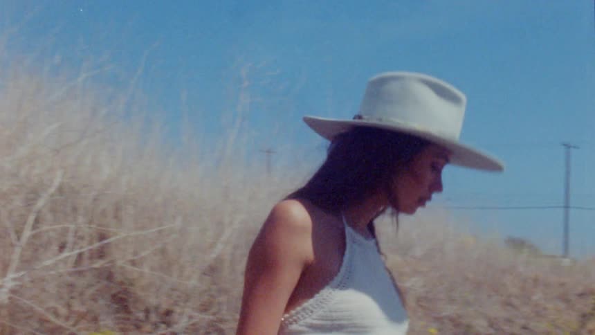 A woman walks down the hill on a sunny day