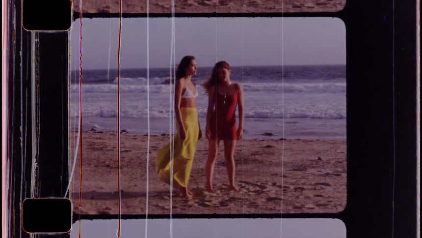 Two women are standing on the beach together