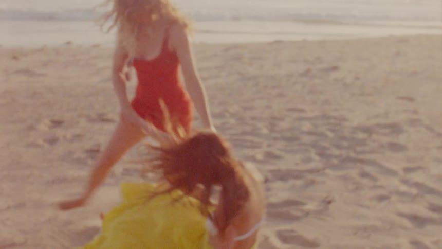 Two women are outdoors at the beach at dusk