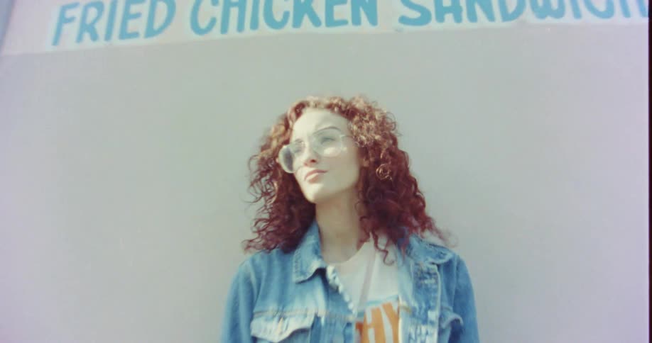 A woman is standing outdoors and posing for the camera