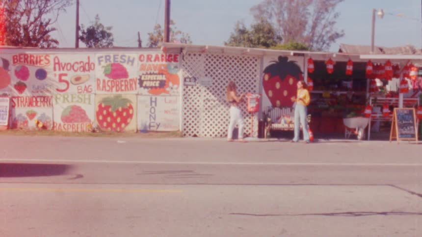 A view of two women talking outdoors next to the street