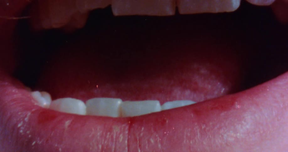 A mustached man holds his mouth open