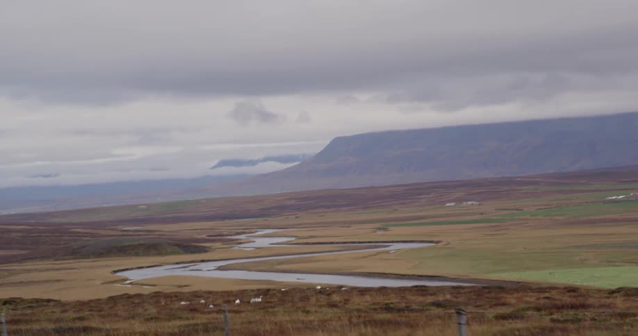 Sheep are on a hill below on a cloudy day