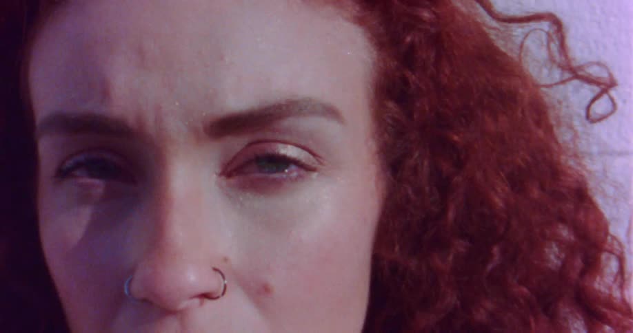Glitter sparkles on a womans face as she stands outdoors