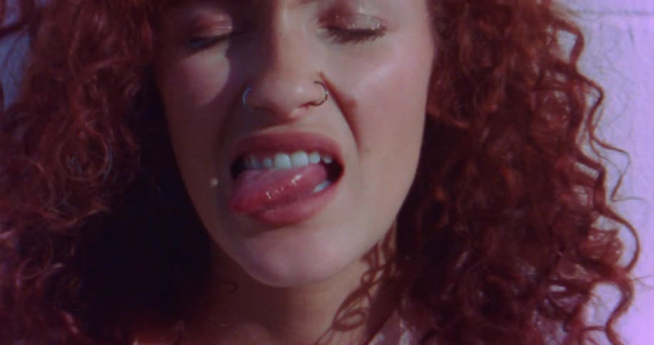 A womans tongue sticking out of her mouth as she grimaces