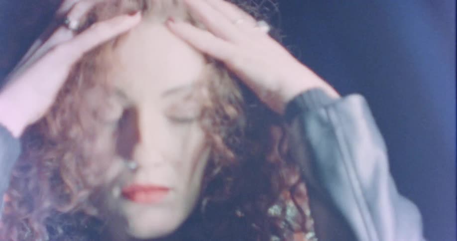 A woman is wearing a jacket indoors at night