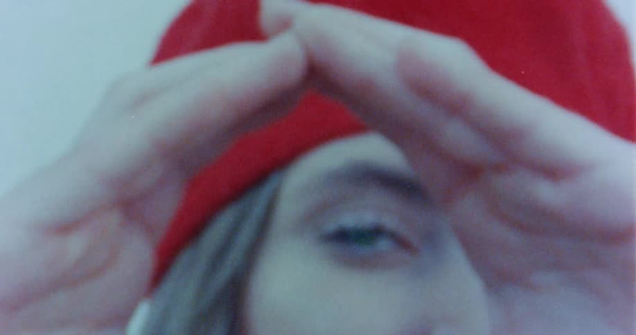Female holding hands up to eye
