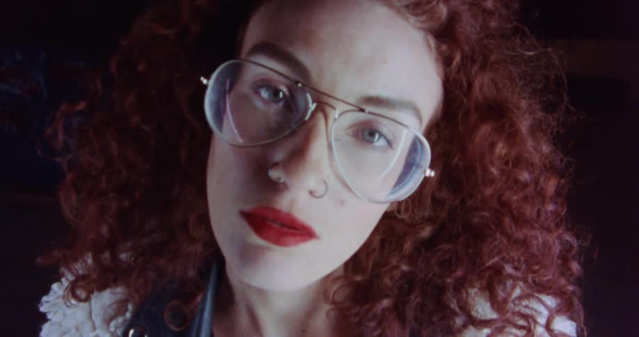 A woman is wearing glasses and posing for the camera