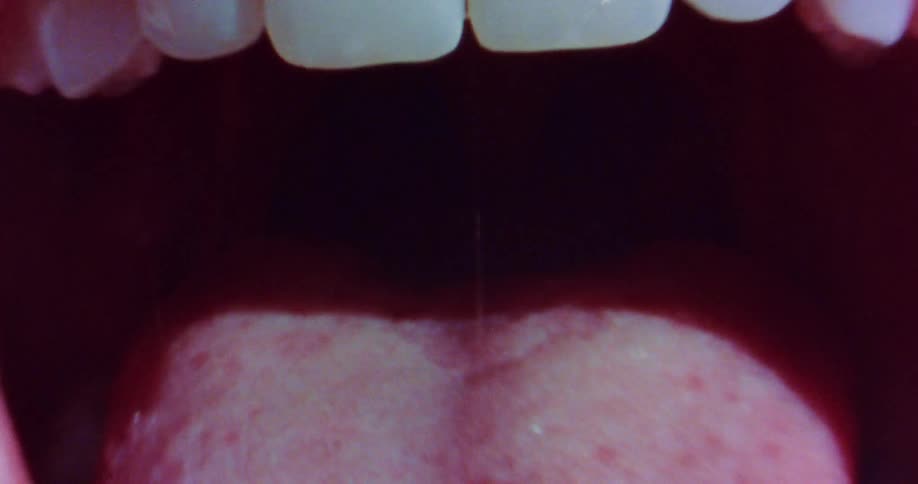 A close up view of an open mouth and a tongue sticking out