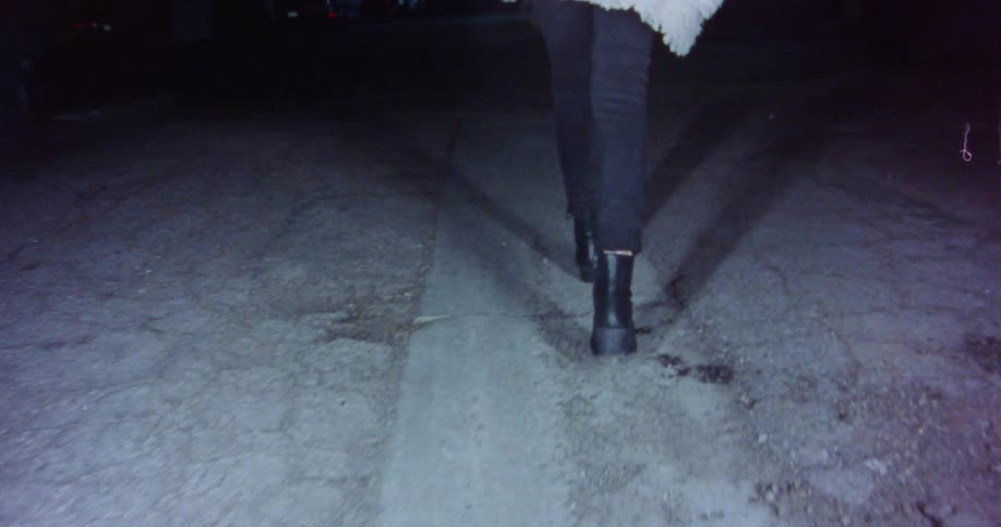 A woman is walking outdoors at night