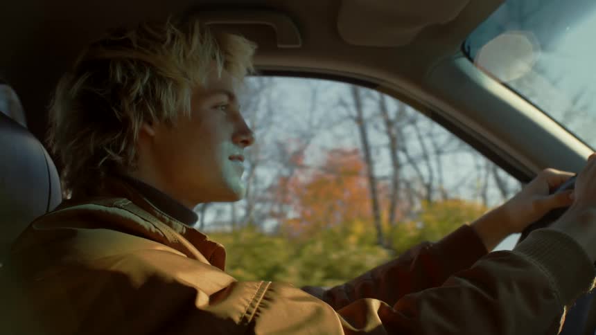 A man driving a car in the middle of the day