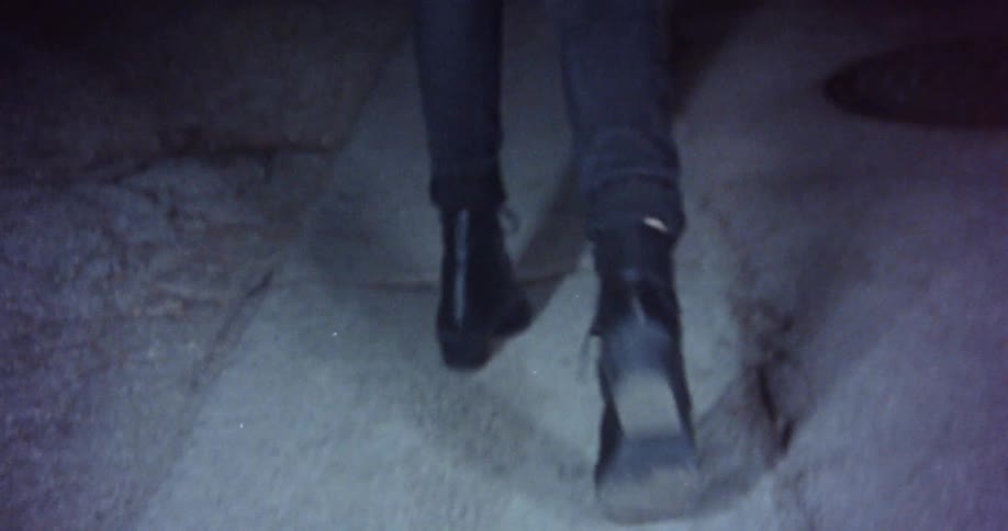 A woman is walking outdoors during the night