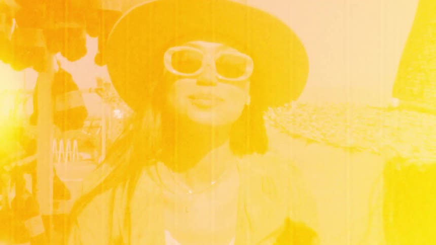 Two friends wearing sun hats and sunglasses eating on a roadside shop