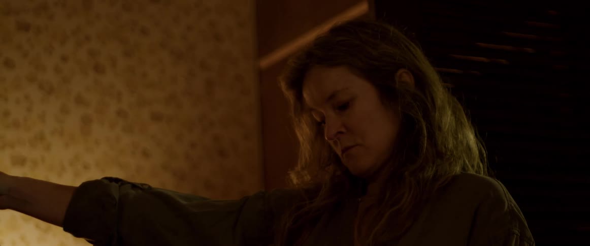 A woman is standing in a dark lit room