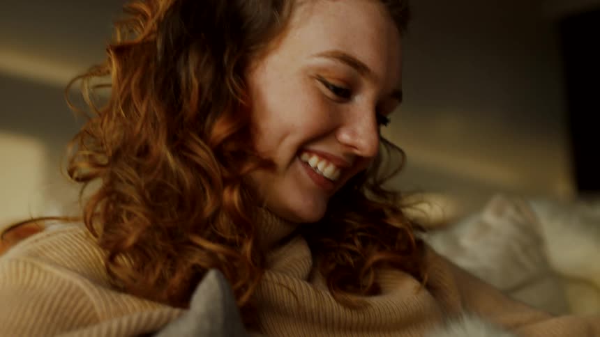 A woman is smiling and looking at her cellphone