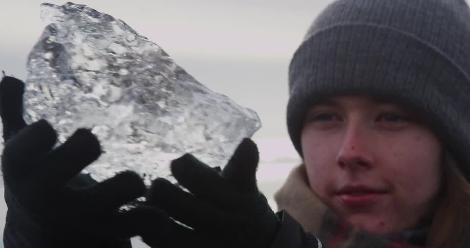 A woman examines a large piece of ice