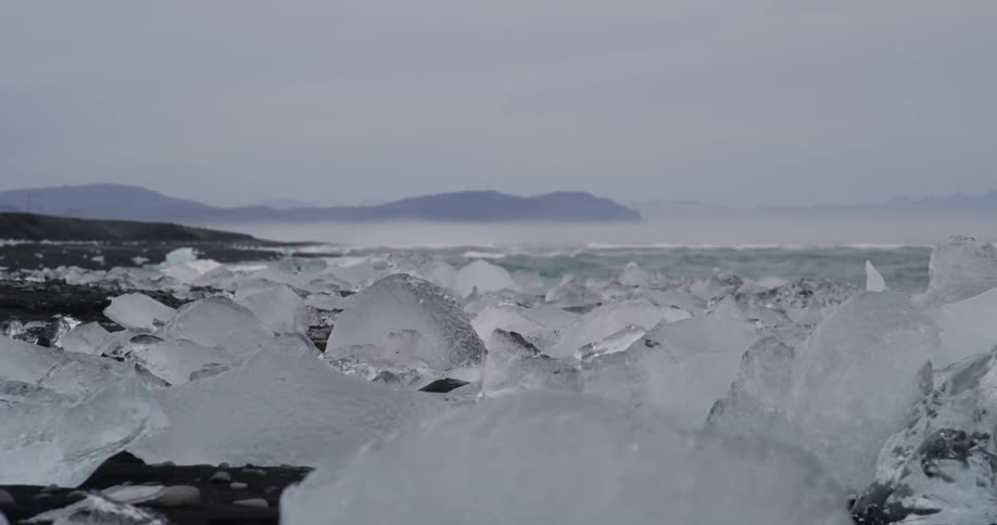 Piece of ice sitting on a frozen shore