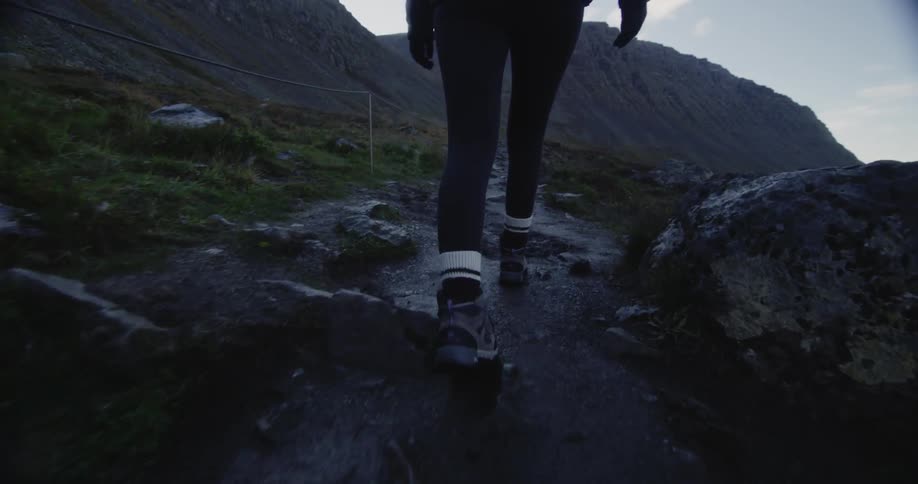 A person is hiking on rocks by the water