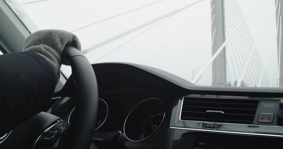 A person is driving over a cable bridge