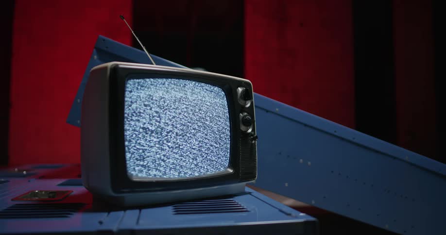 An old model television sits on blue school lockers playing static