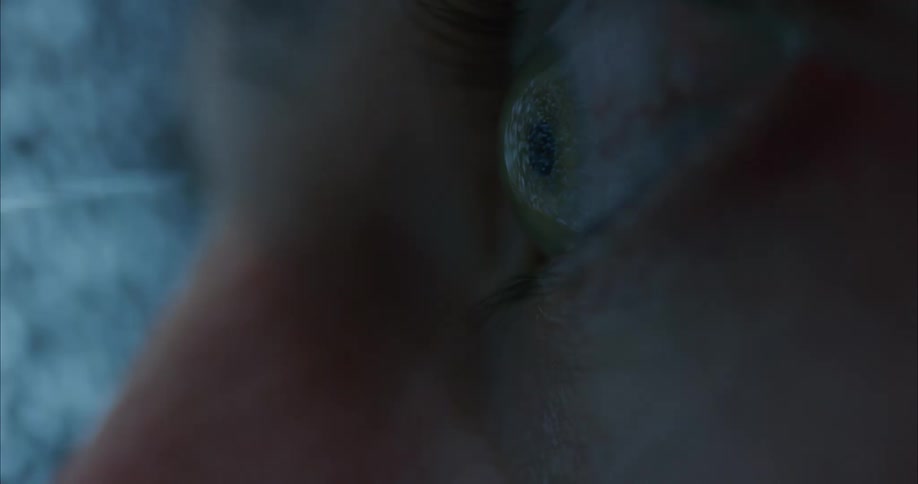A close up of a persons eye as they stare at a fuzzy television screen