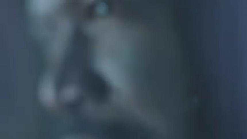 Close up of a mans face as lights flash on him