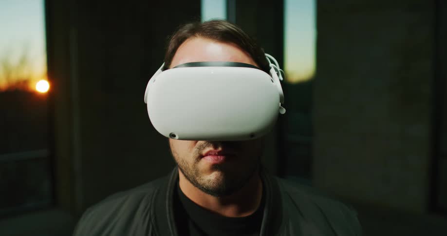 A man is standing outdoors and putting on a virtual reality headset