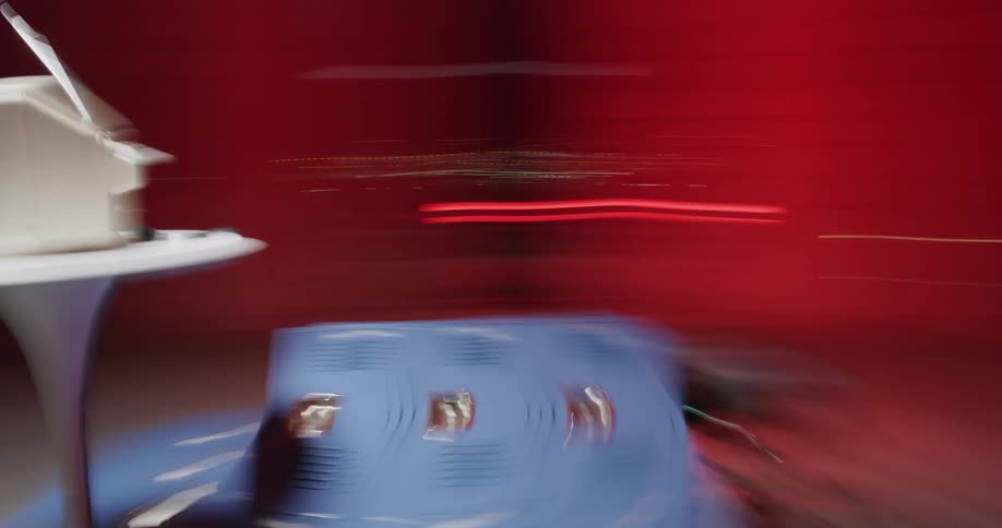 The red lights streak as the television is circled